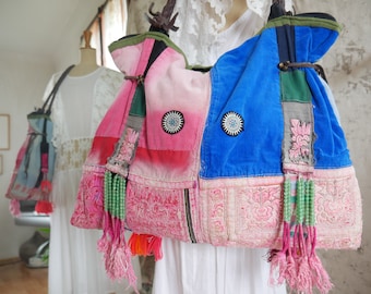 Puede incluir: Un bolso tote de patchwork con tela rosa, azul y verde. El bolso tiene una correa larga y está decorado con borlas y cuentas.