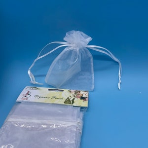 May include: A package of white organza pouches with a label that reads "Organza Pouch".