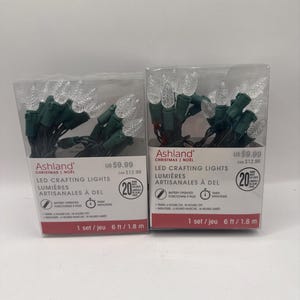 May include: Two boxes of Ashland Christmas LED crafting lights, each containing 20 warm white LED bulbs on a green wire. The packaging indicates the lights are battery operated, include a timer feature, and measure 1.8 metres in total length.