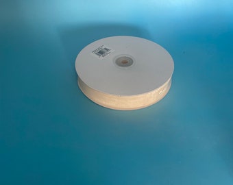 May include: A roll of beige ribbon with a white label on the spool.