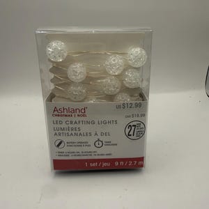 May include: A set of Ashland LED crafting lights in a clear plastic box. The package contains 27 warm white LED lights on a 9 ft wire. The lights feature clear, textured spherical covers. The box includes battery-operated and timer features.