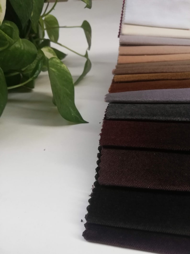 May include: A collection of fabric swatches in various shades of brown, gray, and black. The swatches are arranged in a row, with the lightest shade at the top and the darkest shade at the bottom.
