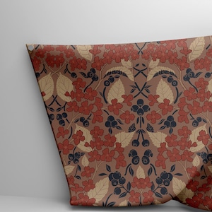 Può includere: Campione di tessuto con motivo floreale ripetuto. Il design include fiori rossi, foglie beige e bacche blu scuro su sfondo marrone. Il tessuto è appuntato su una superficie bianca.