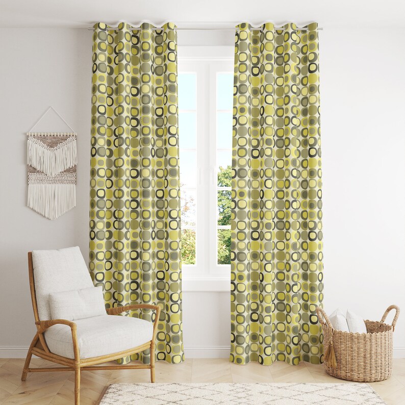May include: A pair of yellow and green patterned curtains with a geometric design. The curtains are hung on a window with a white frame.