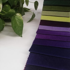 May include: A collection of fabric swatches in various shades of green, purple, and blue. The swatches are arranged in a gradient from light to dark.