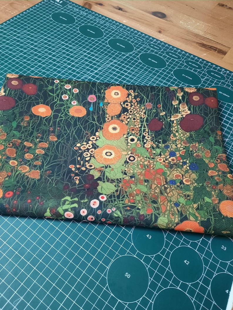 May include: A rectangular piece of fabric featuring a dense, dark green background covered in a vibrant floral pattern. The design includes numerous orange, red, and yellow flowers with green stems and foliage, creating a detailed botanical print.