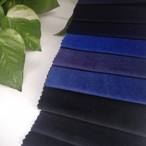 May include: A collection of fabric swatches in various shades of blue and black. The swatches are arranged in a fan shape, with the darkest shade at the bottom and the lightest shade at the top.