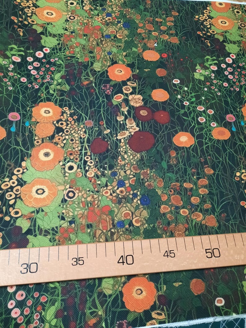 May include: A fabric featuring a dense floral pattern with orange, red, and pink flowers on a dark green background, positioned above a wooden ruler showing measurements from 30 to 50 centimeters, indicating the scale of the botanical print.