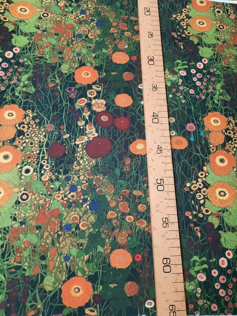 May include: A fabric featuring a dense floral pattern with orange, red, and yellow flowers on a dark green background. A wooden ruler is placed vertically on the right side, showing measurements from 20 to 65 inches for scale reference.