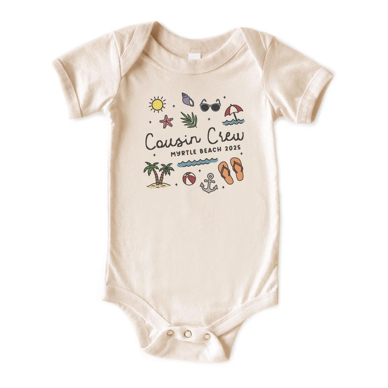 K&ouml;nnte beinhalten: Cremefarbener Baby-Body mit Strandmotiv. Das Design umfasst eine Sonne, Sonnenbrille, Palmen und den Text "Cousin Crew Myrtle Beach 2025". Der Body hat kurze &Auml;rmel und Druckkn&ouml;pfe.