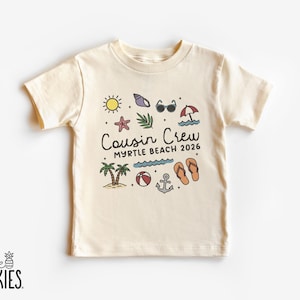 K&ouml;nnte beinhalten: Cremefarbenes T-Shirt mit Strandmotiv und dem Text "Cousin Crew Myrtle Beach 2026". Das Design umfasst eine Sonne, Sonnenbrille, Seestern, Palmen und andere Strandelemente.