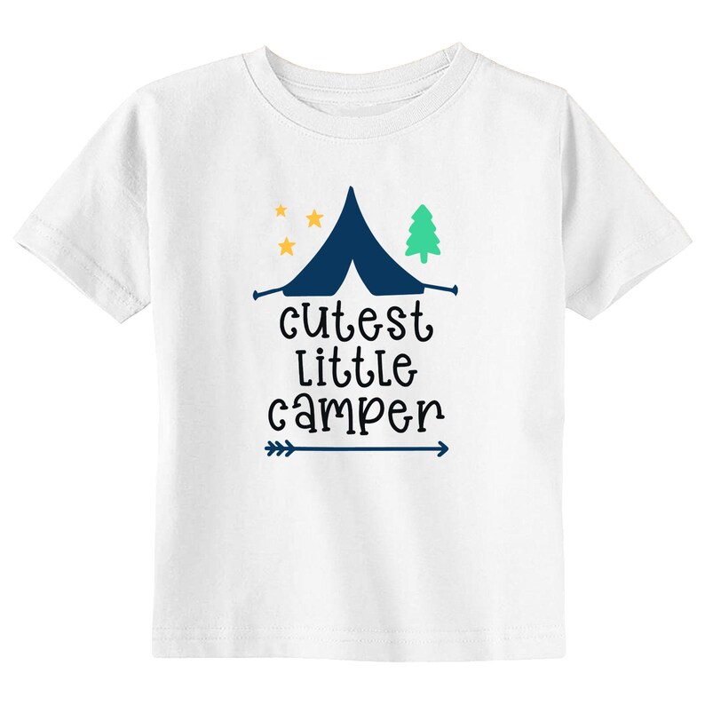 May include: White t-shirt featuring a navy blue tent, a green tree, and three yellow stars. The text "cutest little camper" is printed below the tent, with a blue arrow underneath. A fun design for camping enthusiasts.