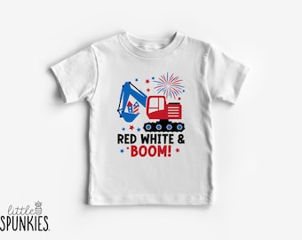 May include: A white short-sleeve t-shirt featuring a graphic of a blue and red excavator carrying fireworks. Above the excavator is a firework burst. Below the graphic is the text RED WHITE & BOOM! in black and red with small blue and red stars.