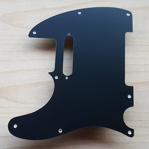 May include: Black guitar pickguard with multiple screw holes.
