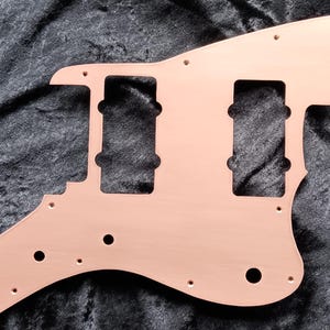 May include: A copper-colored guitar pickguard with three pickup cutouts and multiple screw holes.