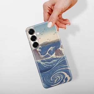 May include: A smartphone case featuring a printed reproduction of a Japanese woodblock print depicting stylized blue ocean waves, swirling water patterns, and distant landforms. The case has three circular camera lens cutouts on the back.