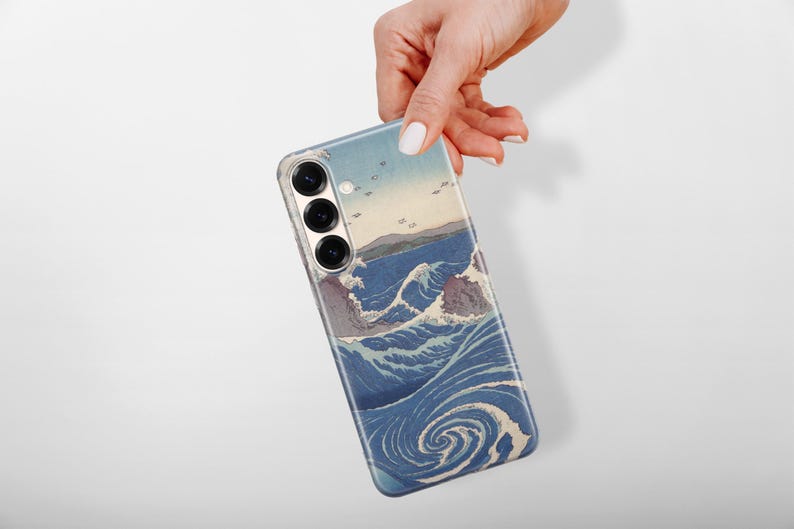 May include: A smartphone case featuring a printed reproduction of a Japanese woodblock print depicting stylized blue ocean waves, swirling water patterns, and distant landforms. The case has three circular camera lens cutouts on the back.