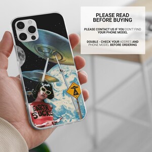 May include: A clear phone case with a colorful collage design featuring a woman wearing sunglasses and a shirt that says "Earth Sucks". The background is a space scene with flying saucers and a planet.