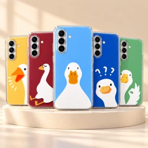 May include: Five clear smartphone cases featuring white goose illustrations on colorful backgrounds. The cases display yellow, red, light blue, dark blue, and green backings with various goose expressions, including a question mark graphic.
