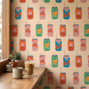 以下が含まれることがあります： ベージュ色の壁に、カラフルなソーダ缶のイラストが繰り返されています。缶には、スイカ、桃、レモン、イチゴなどのフルーツのデザインが施され、テキストラベルが付いています。各缶にはストローが付いています。窓と、コーヒーカップの置かれたテーブルが前景にあります。