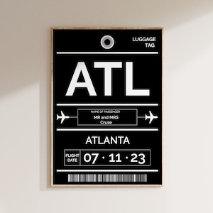 May include: A black and white luggage tag with the airport code ATL, the city name Atlanta, and the flight date 07.11.23. The tag also includes the name of the passenger, MR and MRS Cruse.