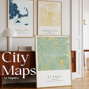 May include: Three framed city map prints. The top left map is Cape Cod, Massachusetts, in navy blue. The top right map is Kansas City in yellow. The bottom map is St. Paul, Minnesota, in green and yellow. The text "City Maps" is displayed.