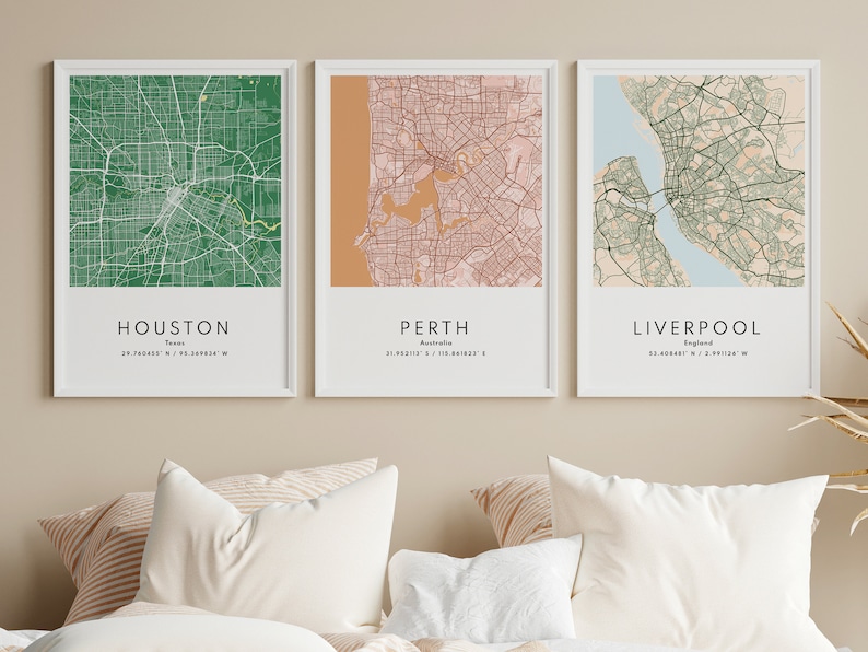 May include: Three framed city maps with white frames and a white background. The maps are of Houston, Texas; Perth, Australia; and Liverpool, England. Each map is in a different color scheme, with Houston in green, Perth in pink and brown, and Liverpool in green and blue.