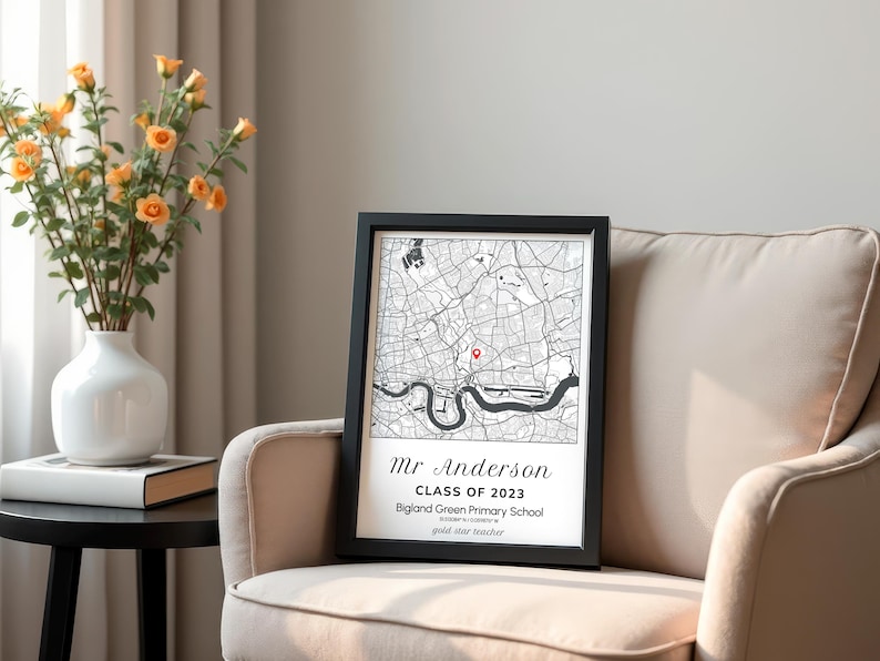 May include: A framed black and white map print with a red marker. The print includes the text "Mr Anderson Class of 2023 Bigland Green Primary School". The print is displayed on a beige armchair.