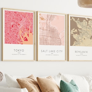 May include: Three framed city maps with a pink, beige, and brown color scheme. The maps are labeled "Tokyo, Japan", "Salt Lake City, Utah", and "Reykjavik, Iceland".