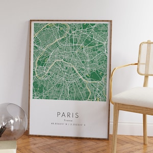 May include: A framed green and white map of Paris, France. The map shows the city streets and landmarks. The text "PARIS" and "France" is printed below the map, along with the coordinates "48.856613&deg; N / 2.352233&deg; E".