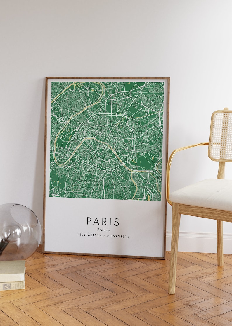 May include: A framed green and white map of Paris, France. The map shows the city streets and landmarks. The text "PARIS" and "France" is printed below the map, along with the coordinates "48.856613&deg; N / 2.352233&deg; E".