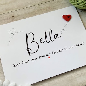 Pu&ograve; includere: Carta bianca con testo nero che recita "Bella Gone from your side but forever in your heart" con un cuore rosso e un cuore rosso con un'impronta di zampa sopra il testo.