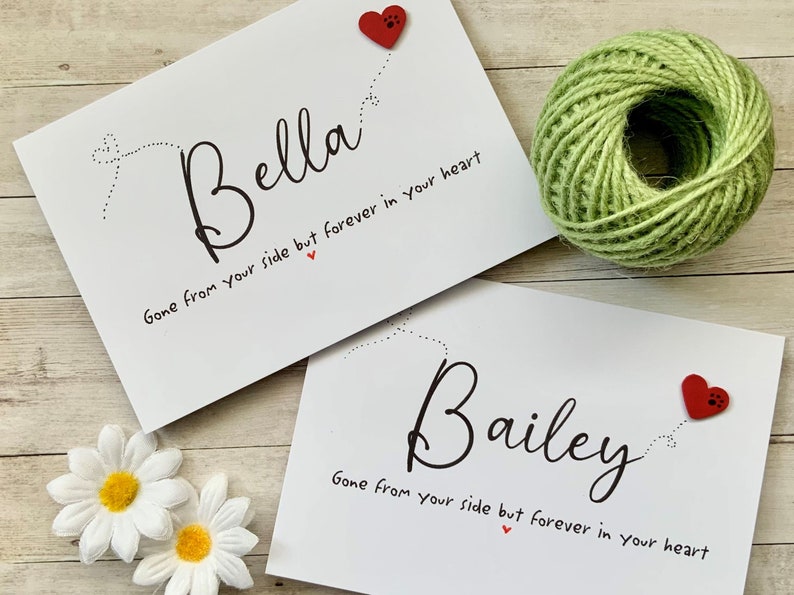 Pu&ograve; includere: Due carte bianche con testo nero e cuori rossi. Il testo sulle carte recita "Bella Gone from your side but forever in your heart" e "Bailey Gone from your side but forever in your heart".