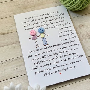 May include: A white card with a handwritten message about being there for someone. The card features two stick figures with buttons for heads. The text reads, "In case you need me, I'm here. I might not have all the answers or be able to wave a magic wand BUT I can reassure you that you're not alone. We can just sit quietly together or we can talk. We can go for a walk in the fresh air or we can scream loudly from the top of our lungs. If you want cheering up I can tell you silly jokes but if you feel like crying, I'll sit beside you. I can't promise to make it better but I can promise that you're not on your own. I'll always be right here."