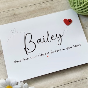 Pu&ograve; includere: Carta bianca con testo nero che recita "Bailey Gone from your side but forever in your heart" con un cuore rosso con un'impronta di zampa.