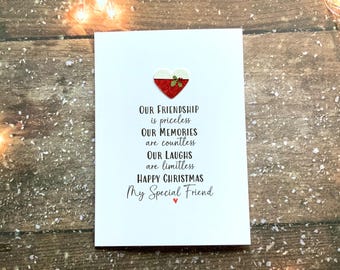 Op de afbeelding: Een witte kerstkaart met een rood glitterhart en de woorden "Our Friendship is priceless, Our Memories are countless, Our Laughs are limitless, Happy Christmas, My Special Friend."