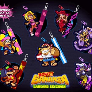 May include: A collection of seven character-themed lanyard keychains featuring various animated figures, including monkeys and humanoids, each with a metal clip and a patterned fabric strap. The text MONKEY BANANZA LANYARD KEYCHAIN is displayed at the bottom.