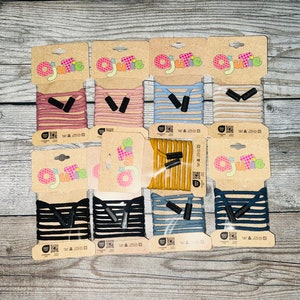 May include: Assortment of 10 colourful shoelaces with black plastic tips. The shoelaces are packaged on cards with the word "Ojute" printed on them.