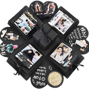 May include: A black explosion box with multiple compartments, each decorated with photos, handwritten messages, and small decorations. The box is tied with a black ribbon and has a small black box inside.