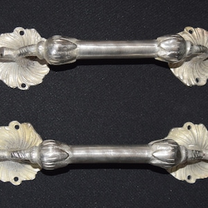 以下が含まれることがあります： 装飾的な花柄の銀色のドアノブが2つ。ノブは金属製で、磨かれた仕上げになっています。