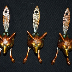 Könnte beinhalten: Drei antike Messing-Fuchstürschläger mit Kupferfinish. Jeder Türschläger zeigt einen detaillierten Fuchs-Kopf mit einem langen, spitzen Schwanz.