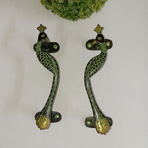 May include: A pair of peacock-shaped door handles with green and gold accents. The handles are made of brass and have a traditional design.