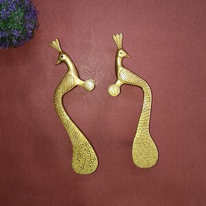 以下が含まれることがあります： 金色の孔雀の形をしたドアノブのペア。ノブは孔雀の羽根で装飾されており、滑らかで磨かれた仕上げになっています。