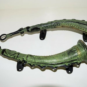 Pode incluir: Duas maçanetas de porta de metal verde em forma de chifre com desenhos intrincados e suportes de montagem de metal preto.