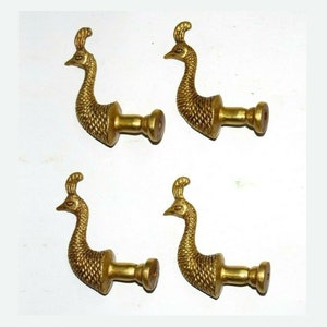 Puede incluir: Conjunto de cuatro ganchos dorados en forma de pavo real. Cada gancho tiene un diseño de pavo real detallado con una base redonda.