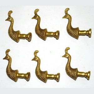 May include: Six gold peacock-shaped door knobs with a textured finish. Each knob has a round base and a decorative peacock design.