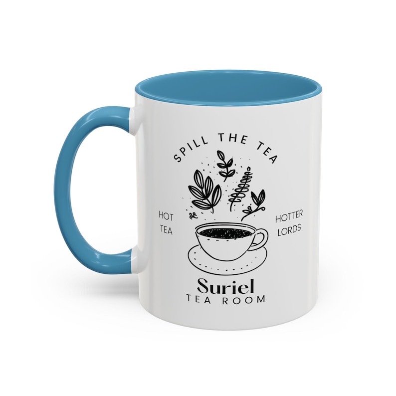 Pode incluir: Caneca de cer&acirc;mica branca com borda e al&ccedil;a azuis. A caneca apresenta uma ilustra&ccedil;&atilde;o em preto e branco de uma x&iacute;cara de ch&aacute; com vapor e folhas, com o texto "Spill the Tea, Hot Tea, Hotter Lords, Suriel Tea Room".