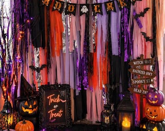 May include: A Halloween-themed display with a backdrop of colorful streamers and a "Boo Crew" banner. The scene includes pumpkins, lanterns, a "Trick or Treat" sign, and a directional sign. Bats and a spider add to the spooky atmosphere.