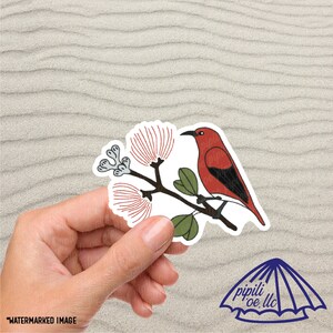 May include: A red and black bird with a long beak perched on a branch with red flowers. The bird is a Hawaiian ʻIʻiwi, a type of honeycreeper.