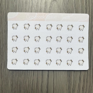 May include: A sheet of stickers featuring cartoon teeth with sparkling accents. The stickers are white with black outlines and gold starbursts. The text "CozyBookSleeve - Teeth" is printed at the top.